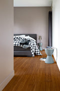 Modern bedroom with a bed, lamp, and side table.