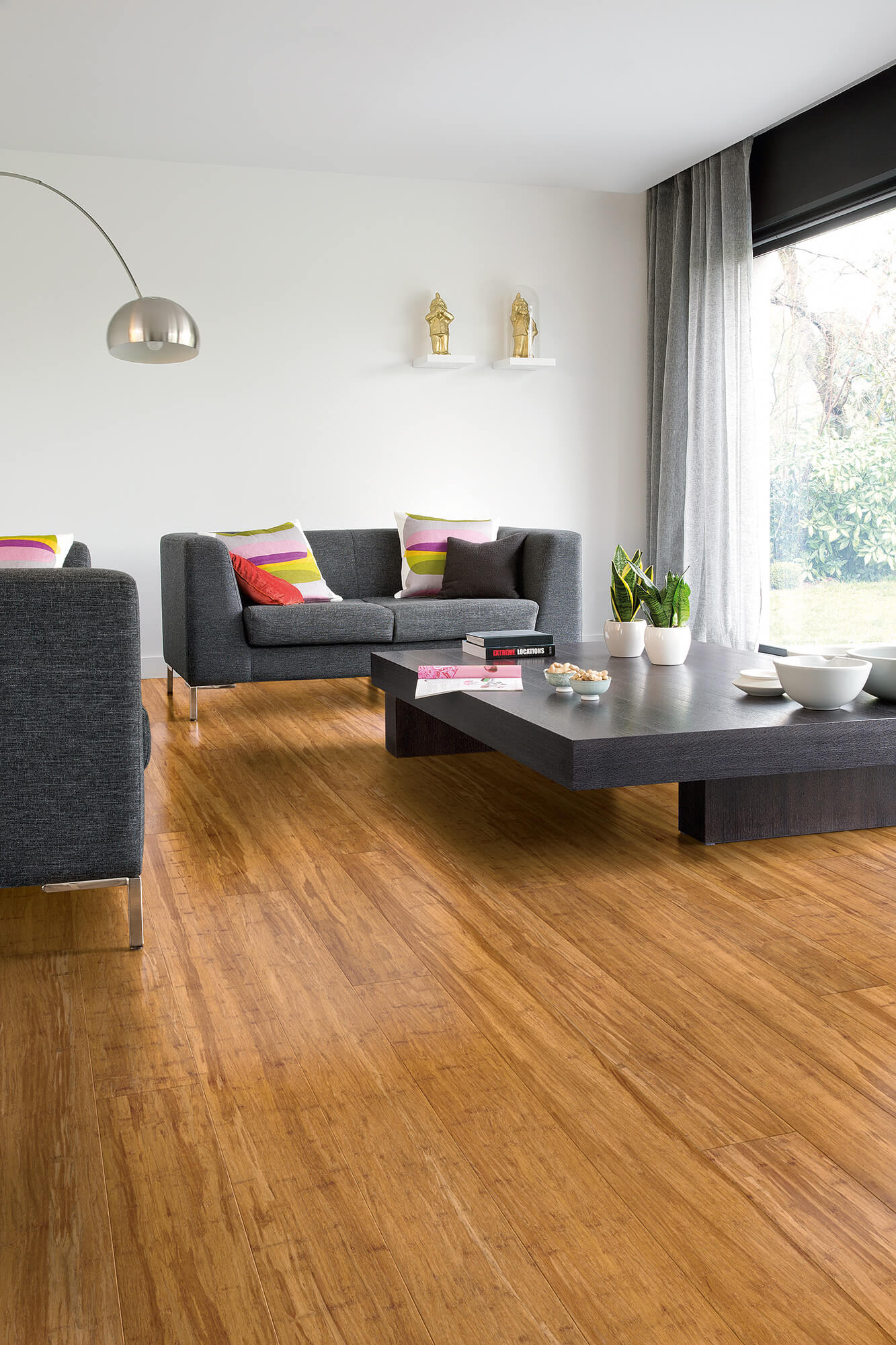 Modern living room with wooden flooring, gray sofa, and decorative elements.