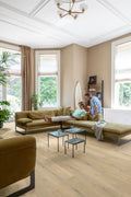 Living room with a beige sectional sofa, coffee tables, and a chandelier.