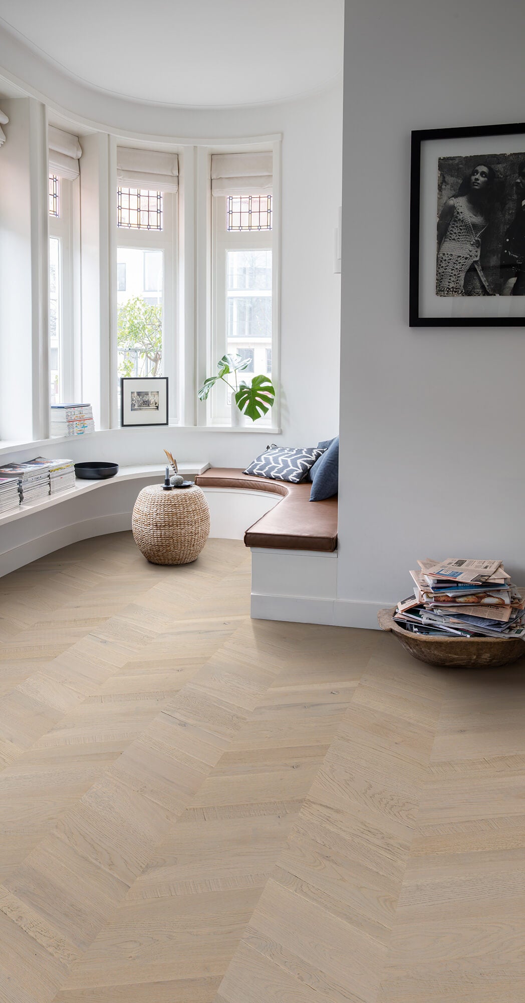 Living room with wooden flooring, windows, and decorative items.