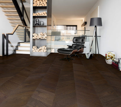 Modern interior with a black leather chair, wooden staircase, and bookshelf.