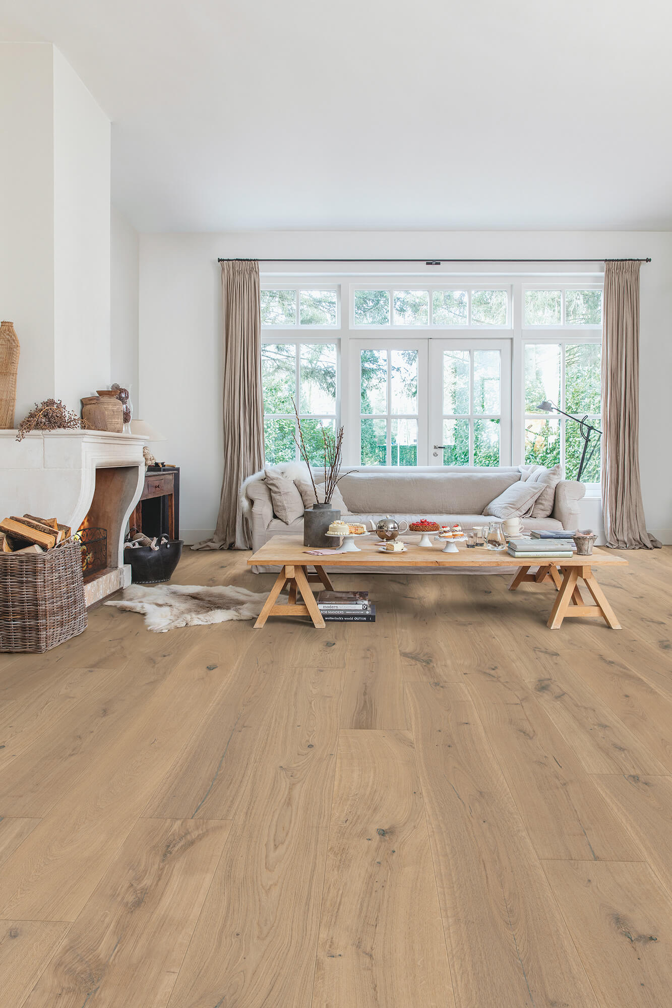 Living room with wooden flooring, sofa, coffee table, and large windows.