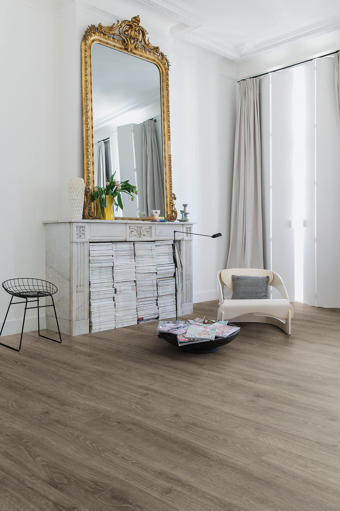 Living room with a large ornate mirror, white sofa, and wooden floor.