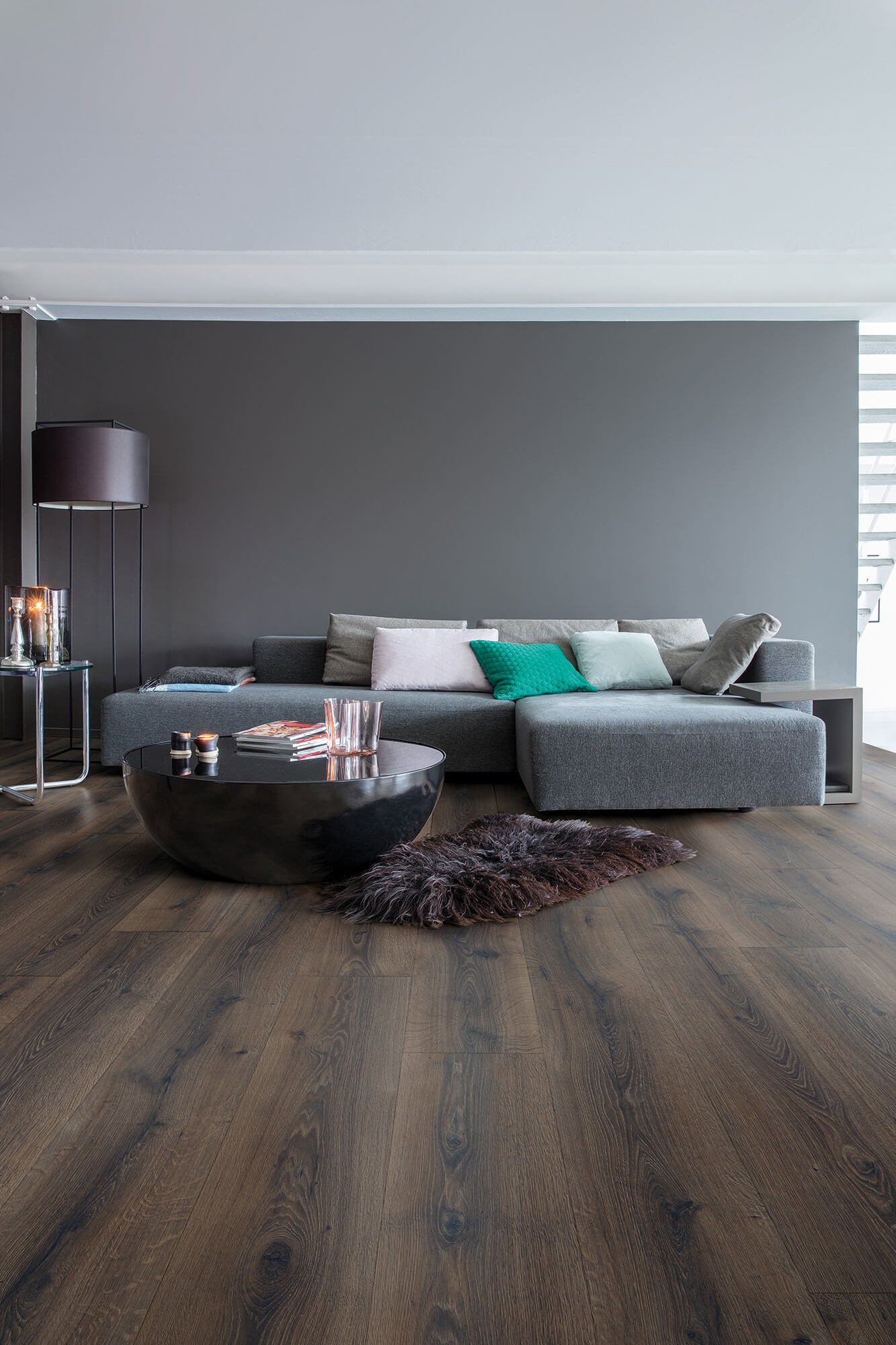 Modern living room with a gray sectional sofa, coffee table, and decorative items.