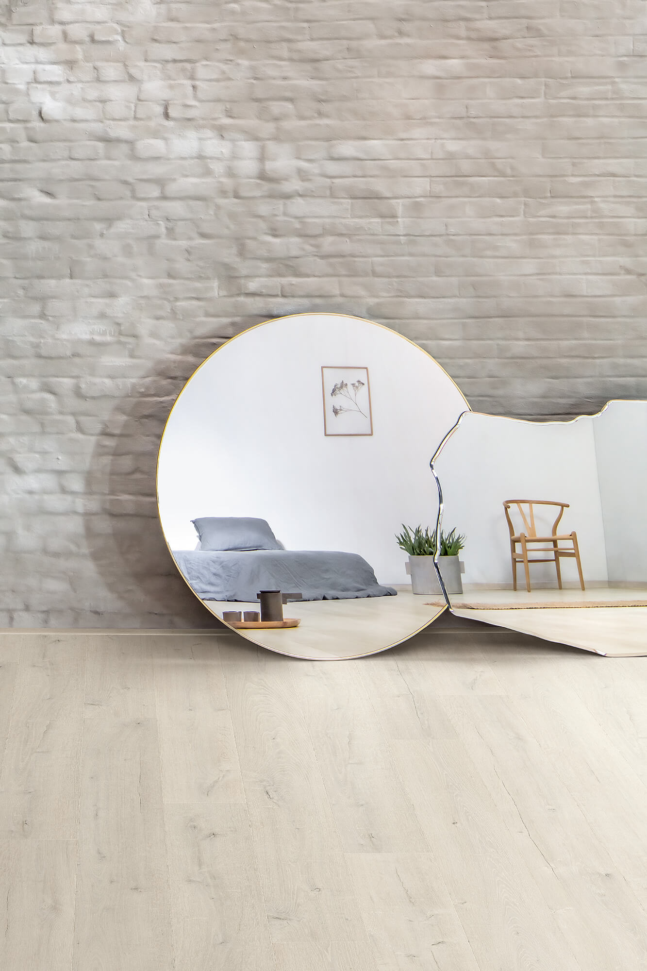 Modern interior design with a round mirror reflecting a bedroom and chair.